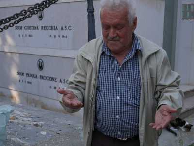 Quel signore si chiama Domenico, ha 78 anni e viene al cimitero ogni giorno alla stessa ora, portando ai gatti gli avanzi di cibo che la figlia prepara quotidianamente, impacchettandoli con cura